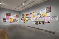 Photograph of Guerrilla Girls artworks installed on the walls of a gallery space