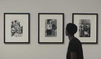 A person looking at three black and white photographs