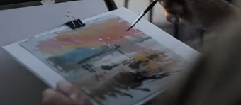 a person paints a watercolour sunset